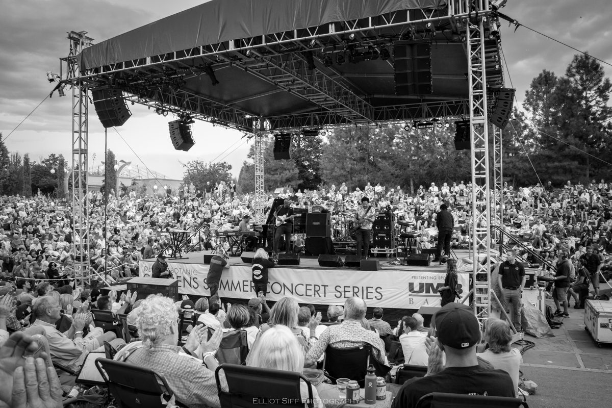 Outdoor concert with large seated audience.