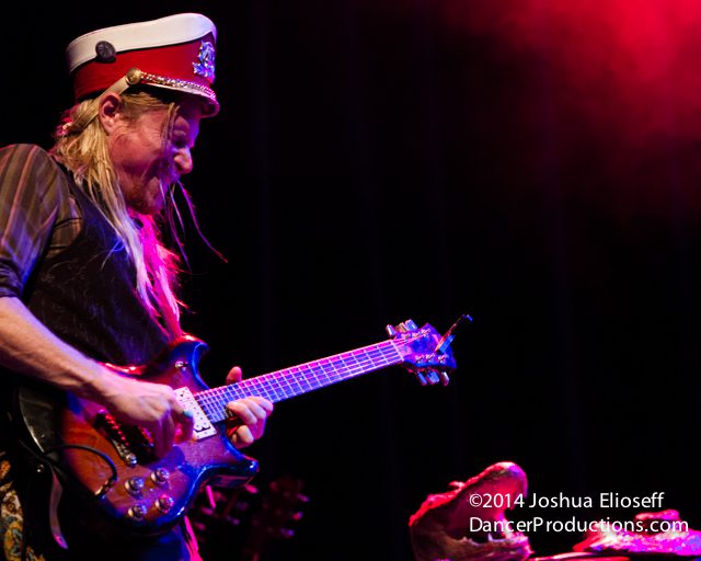 Guitarist performing energetically on stage.