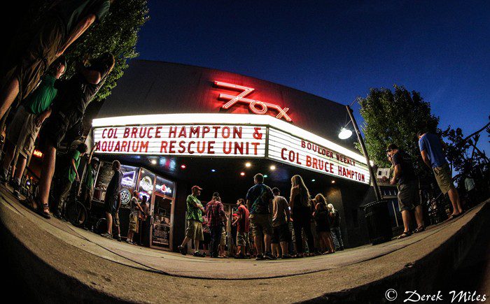 People gathering outside a theater at night.
