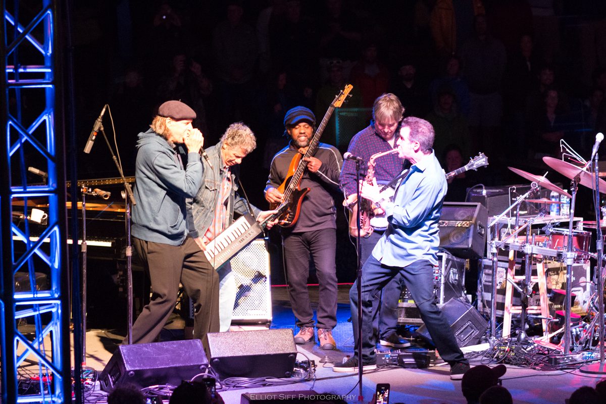 Live band performing on stage with instruments.