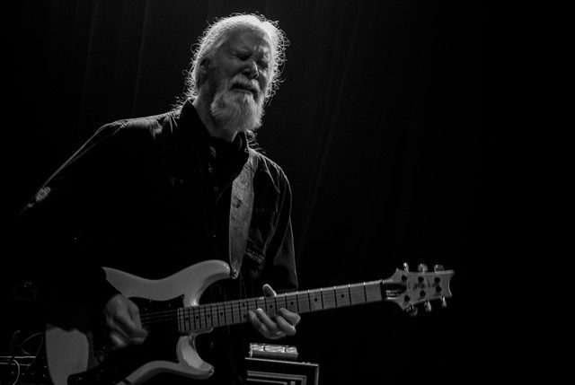 Guitarist performing passionately on stage.