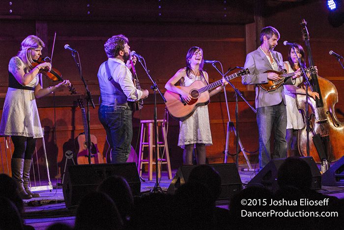 Band performing on stage with musical instruments.