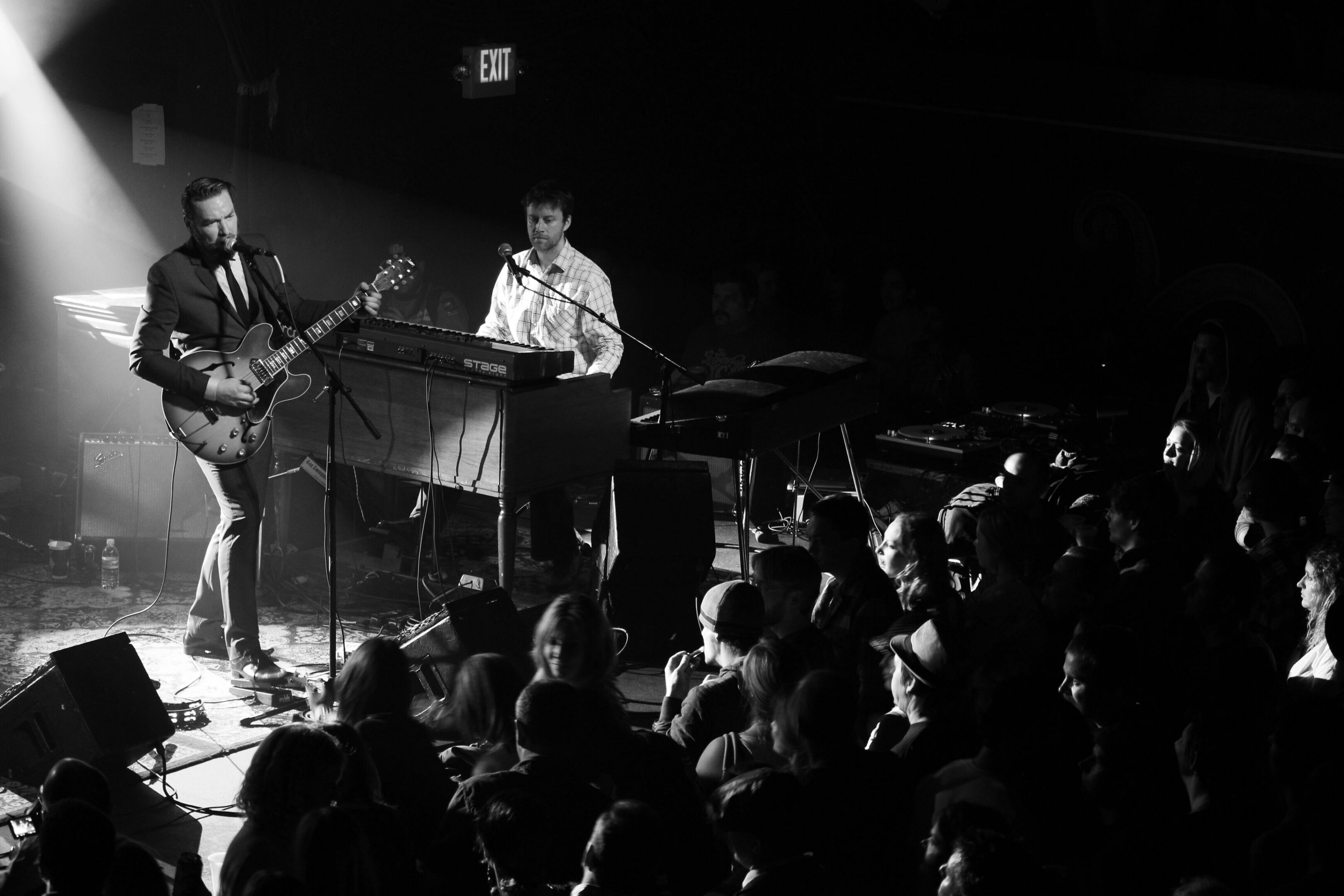Musicians performing on stage to audience.
