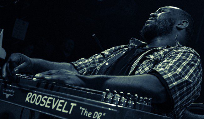 Man playing musical instrument passionately on stage.