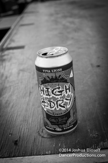 Beer can on wooden table, black-and-white.
