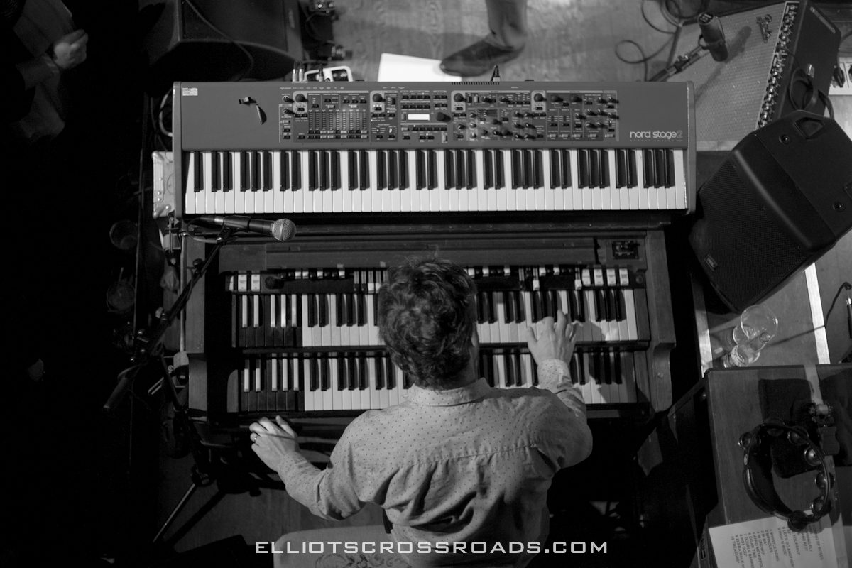 Musician playing keyboards on stage, overhead view.