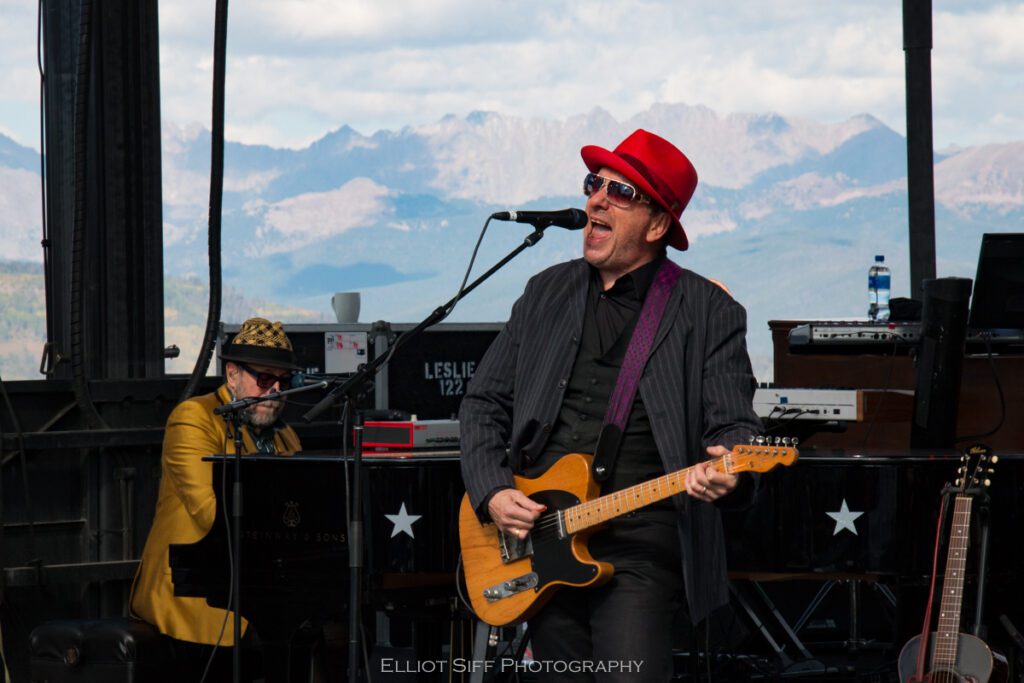 Musician performing on stage with guitarist.