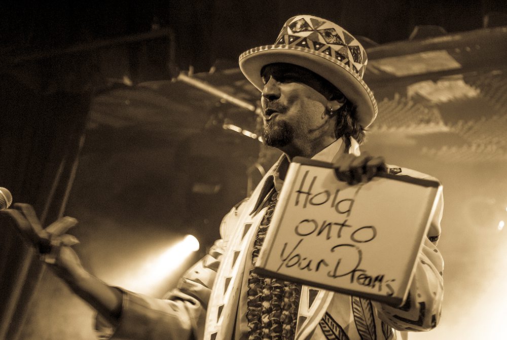 Performer holding sign with motivational message.