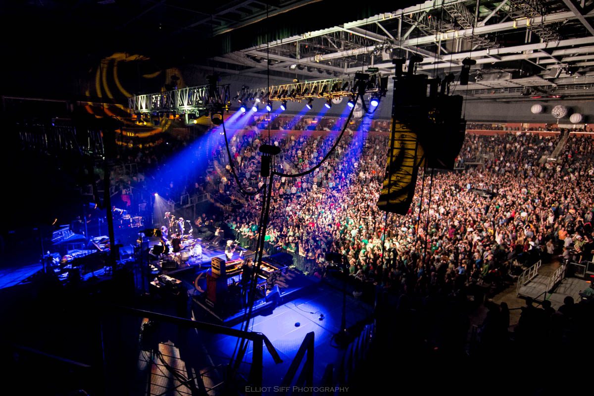 Concert crowd with colorful stage lighting.
