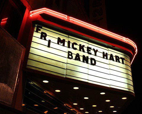 Theater marquee displaying band name at night.