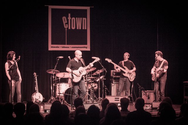 Band performing on stage at eTown concert.