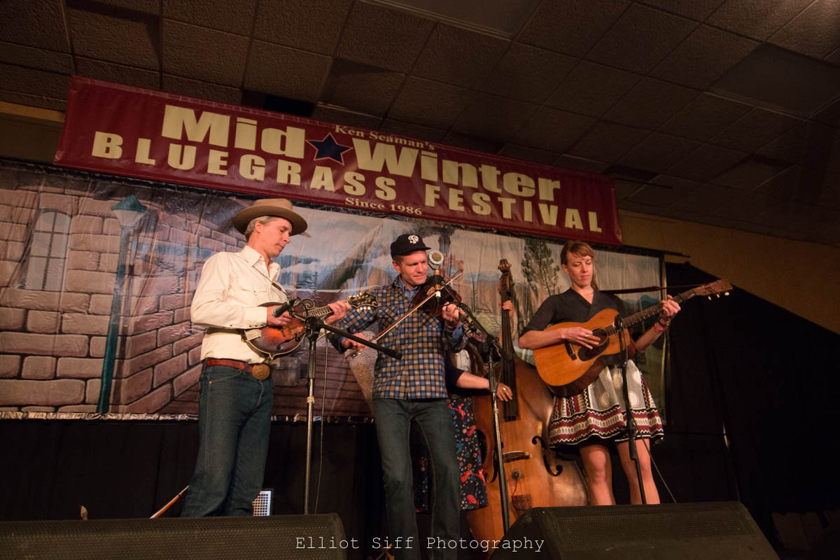Musicians performing at bluegrass festival stage.
