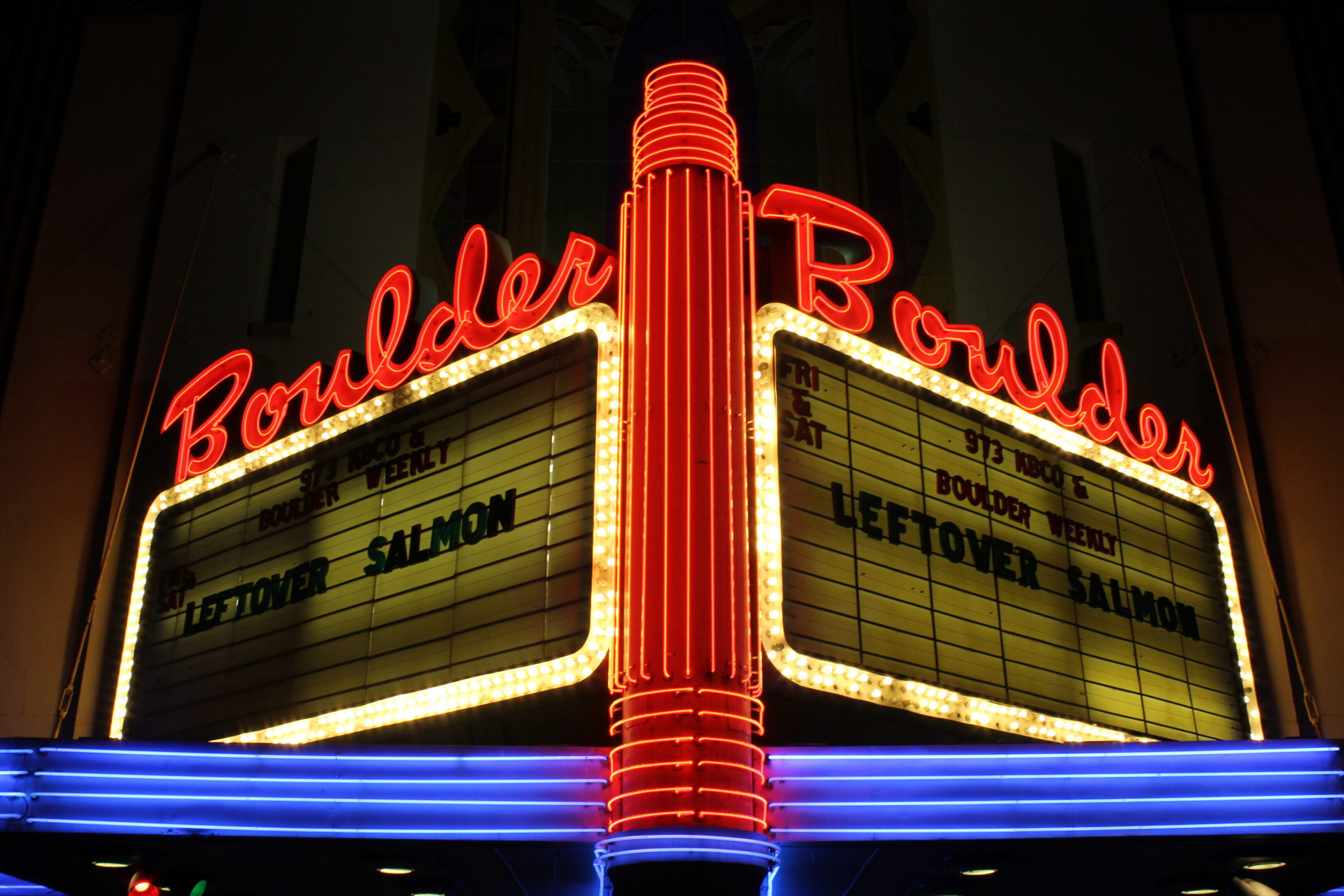 Neon-lit Boulder theater marquee at night.