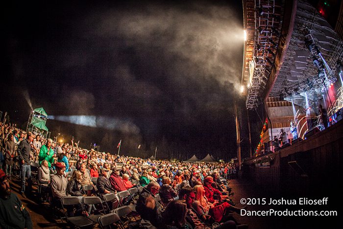 Outdoor concert with large seated audience.