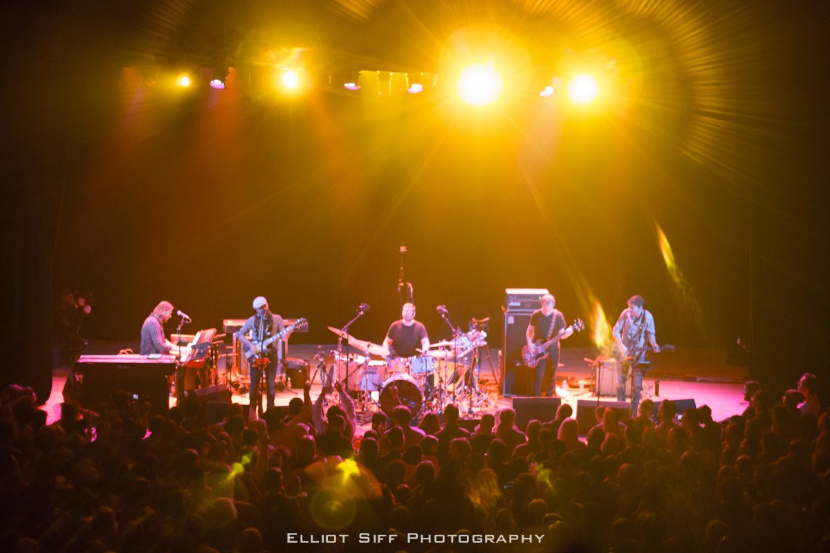 Band performing on stage with audience.