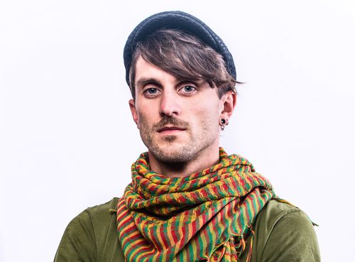 Man wearing hat and colorful striped scarf.