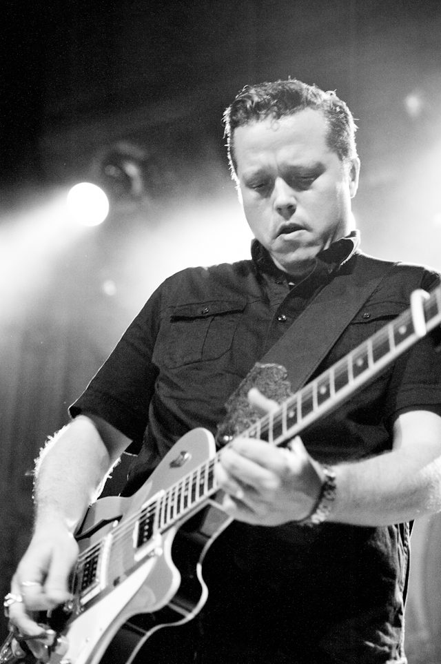 Guitarist playing electric guitar on stage.