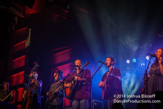 Band performing on stage with instruments.