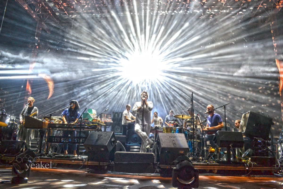 Band performing on stage with bright lights.