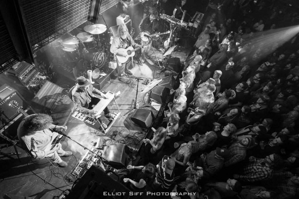 Band performing live on stage with crowd.