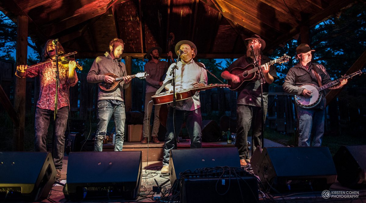 Band performing on outdoor stage at night.