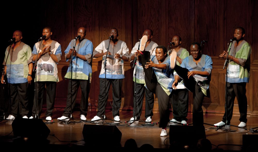 Singers performing on stage with microphones.