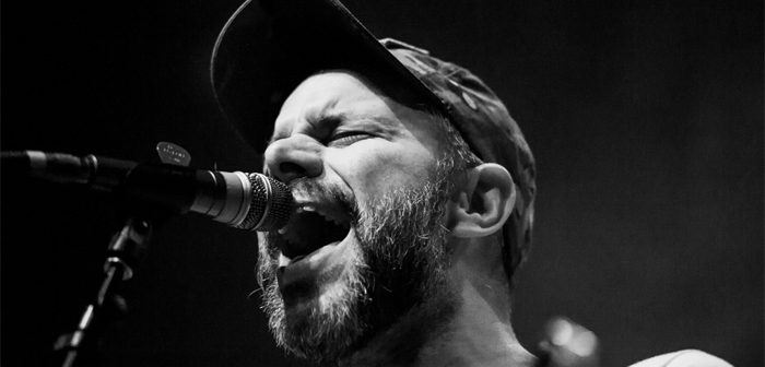 Singer passionately performing on stage, black and white.