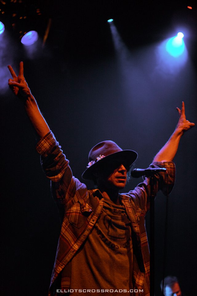 Singer on stage with raised arms.