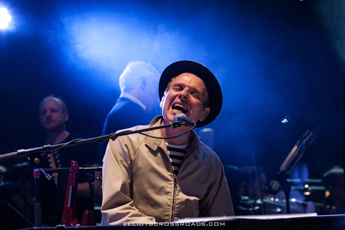 Musician passionately singing and playing keyboard.