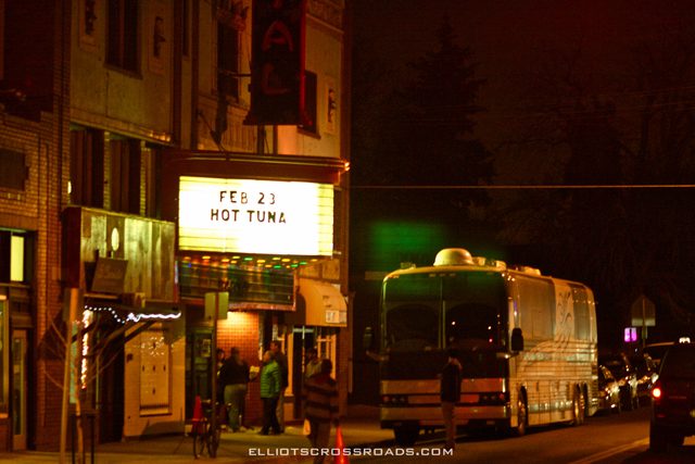 Marquee sign and tour bus at night.