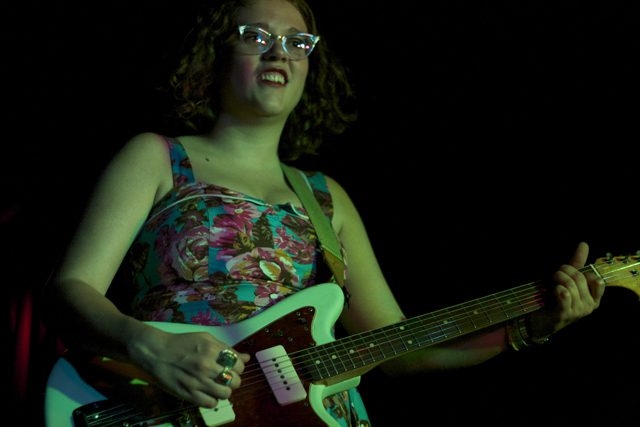 Person playing electric guitar on stage.
