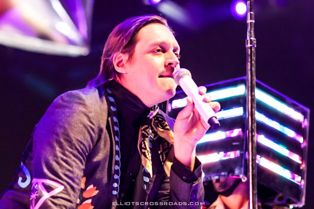 Singer performing on stage with microphone.