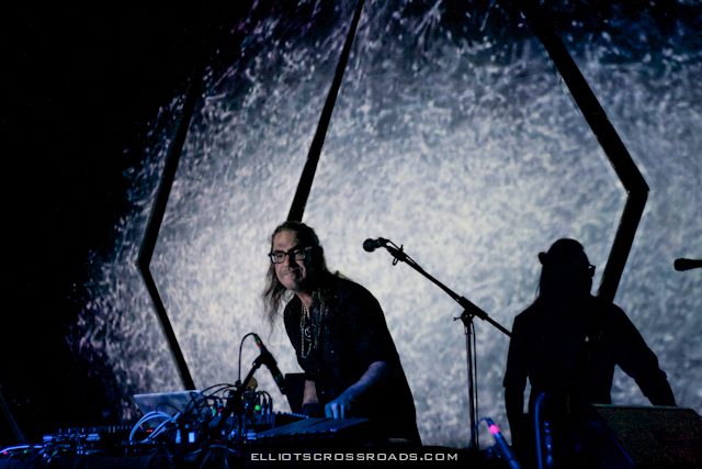 Musician performing with electronic equipment on stage.