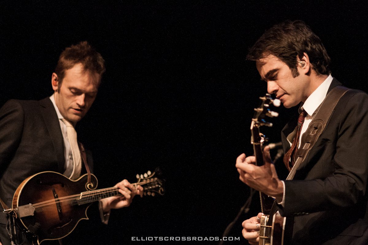 Two musicians playing string instruments on stage.
