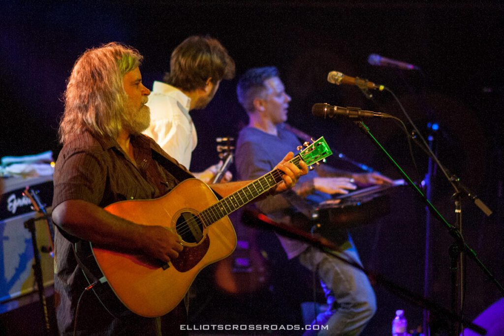 Musicians performing on stage with instruments.