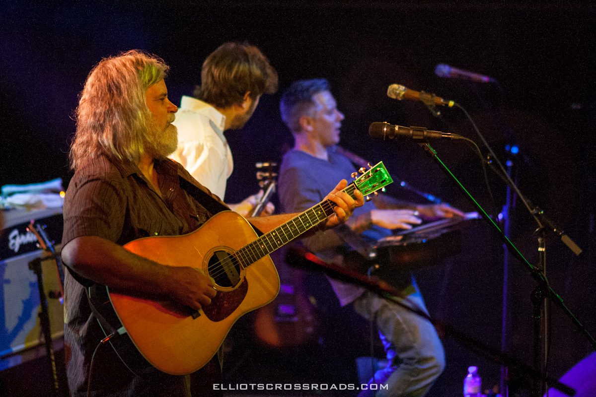 Musicians performing on stage with instruments.