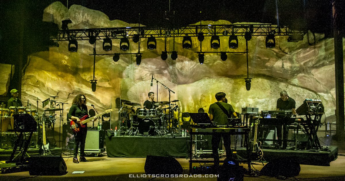Band performing on stage with colorful lighting.