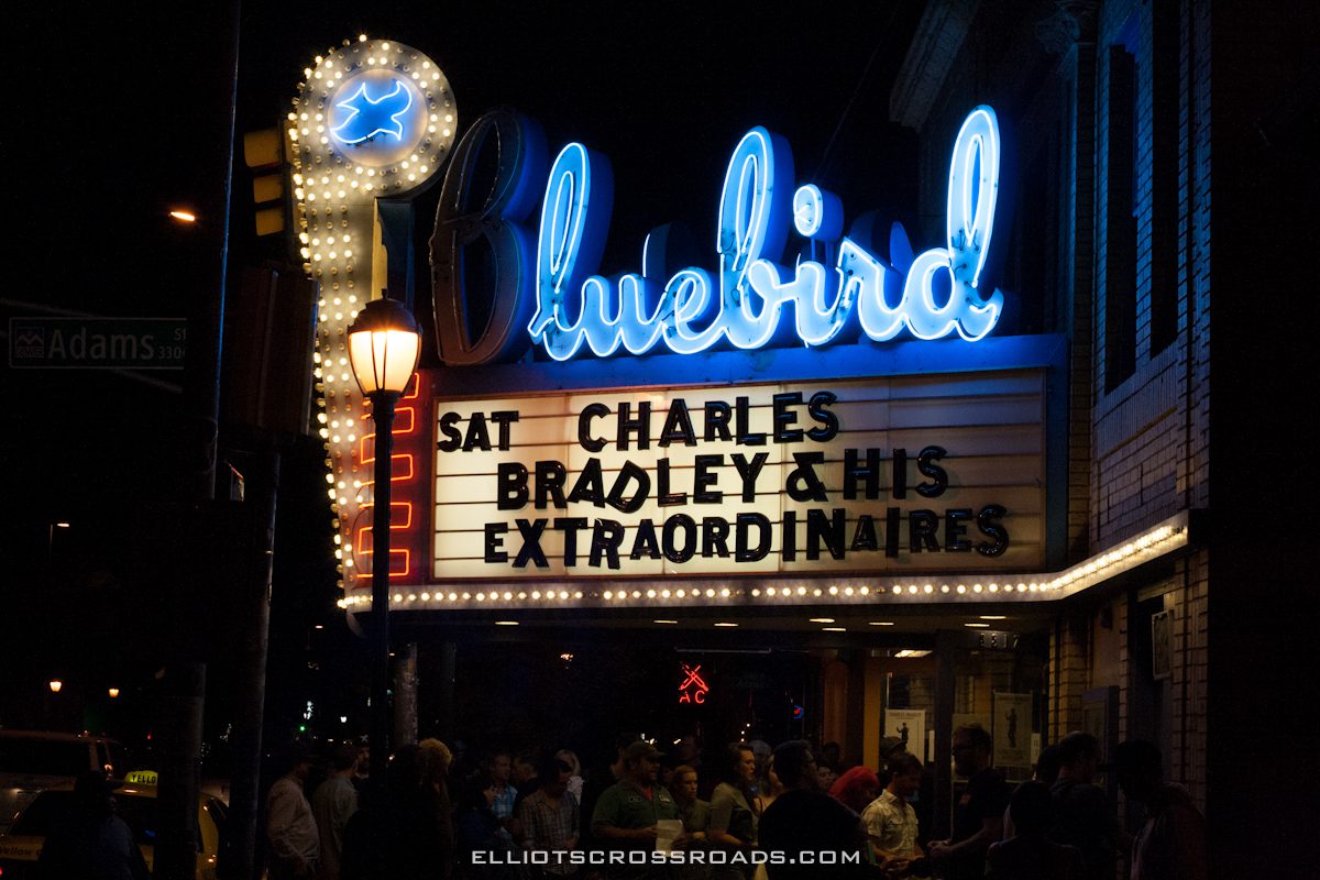 Bluebird Theater marquee at night with crowd.