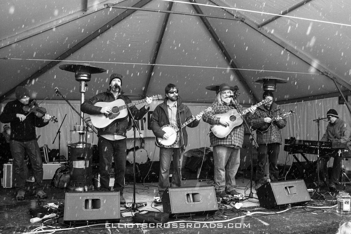 Band performing on outdoor stage in snow.