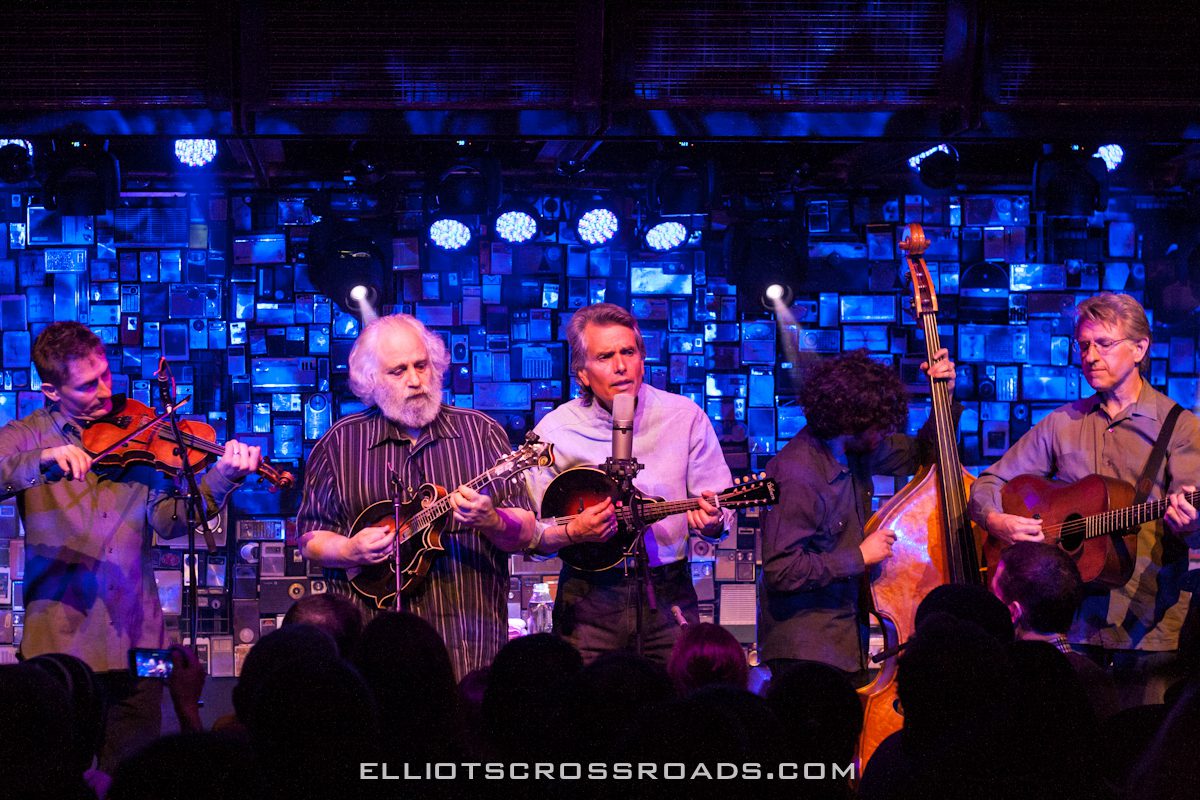 Band performing on stage with blue lighting.