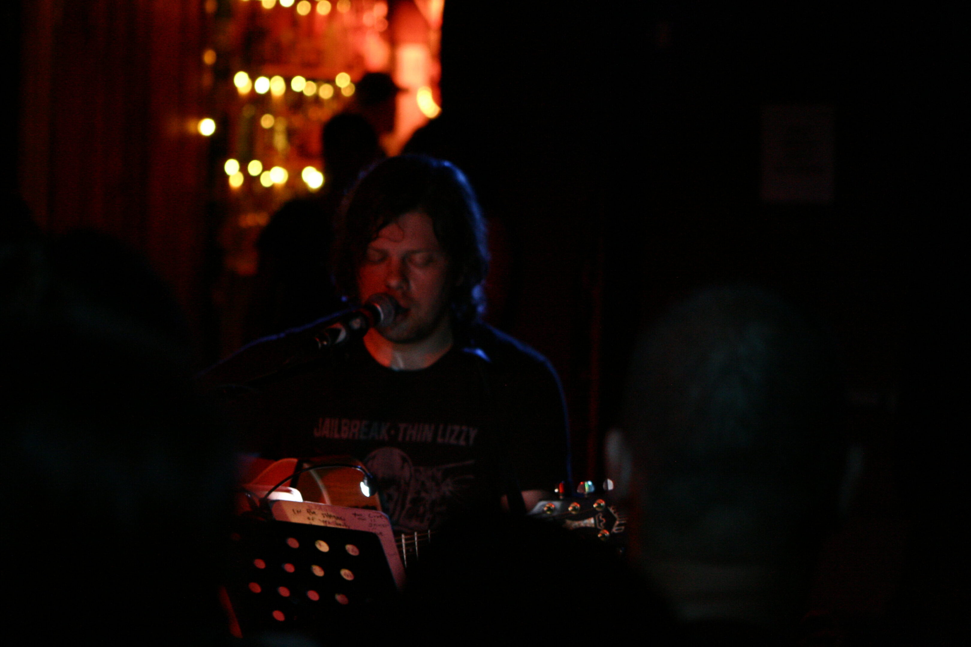 Musician performing on stage with guitar.