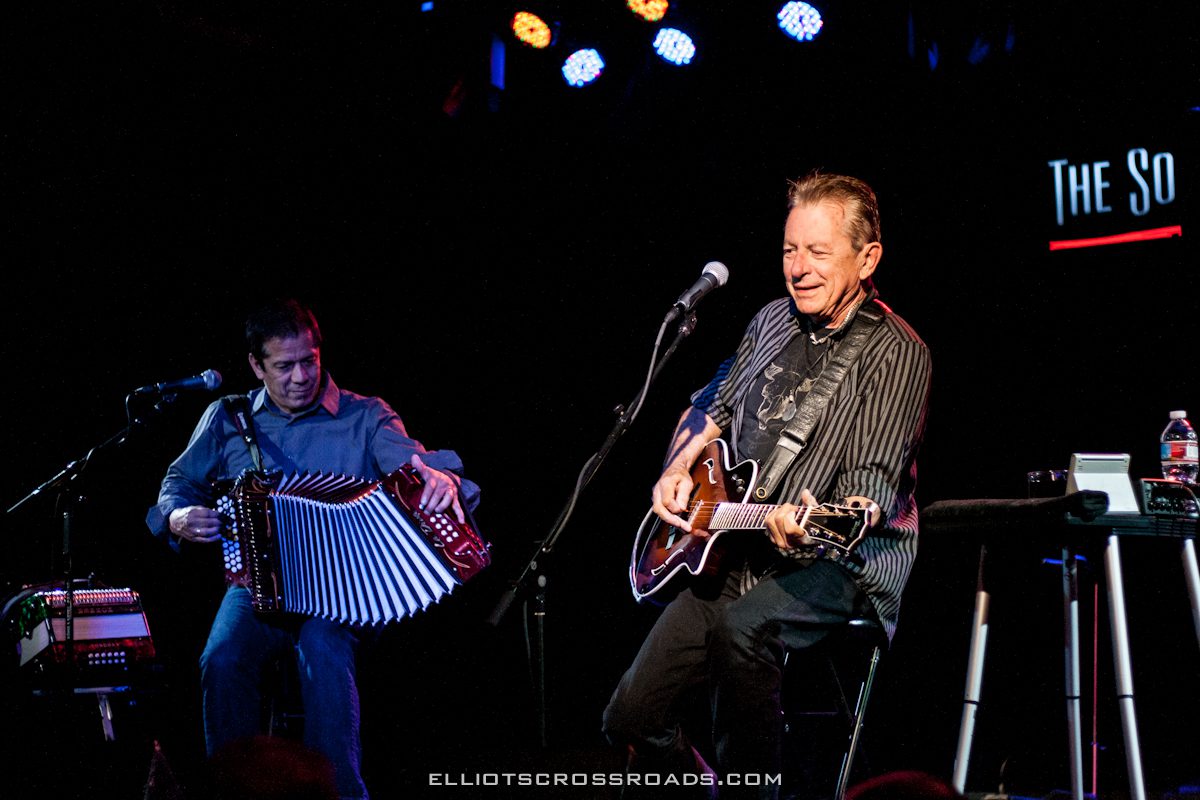 Musicians performing on stage with instruments.