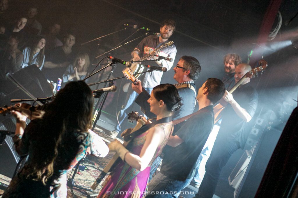 Band performing live on stage with audience.