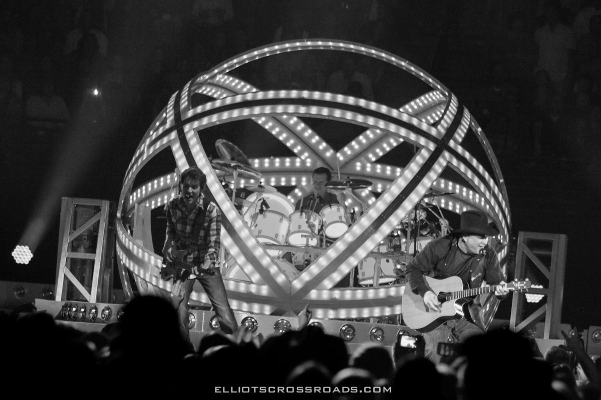 Band performing on stage with illuminated structure.
