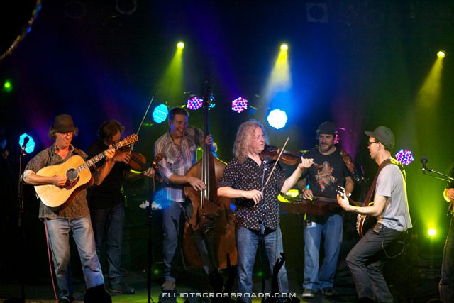 Band performing on stage with colorful lights.