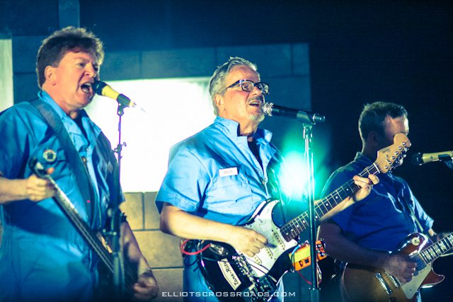 Band performing on stage with instruments.