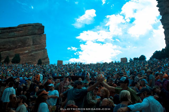 Crowd at outdoor amphitheater under blue sky.