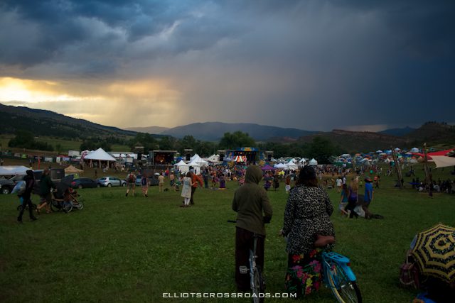 Outdoor festival with tents and gathering crowd.