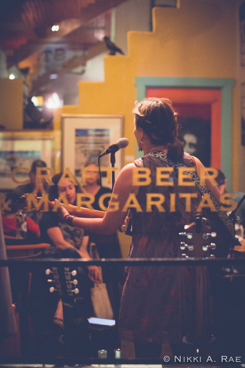 Singer performing in a cozy, colorful venue.