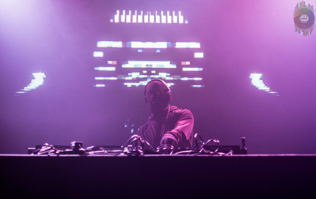 DJ performing on stage with lights.